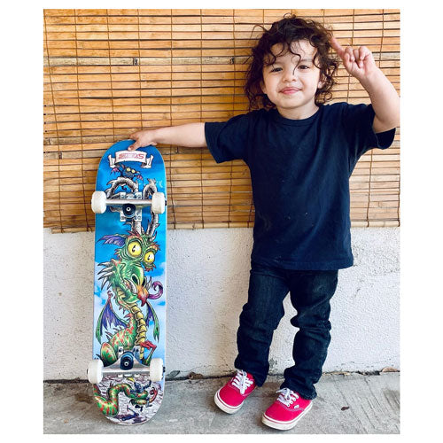 Young boy standing with SkateXS Dragon Kids Skateboard