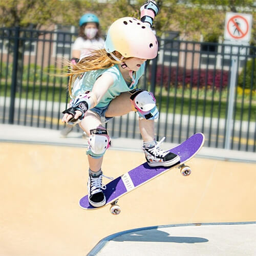 Girl flying on skateboard getting air - SkateXS Skateboards for Kids